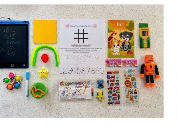 Travel busy bag with writing tablet, stickers, and small toys
