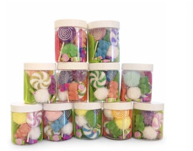 Stack of playdough jar party favors with themed trinkets